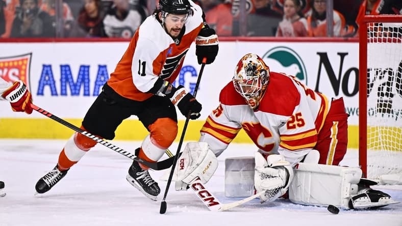 Jan 6, 2024; Philadelphia, Pennsylvania, USA; Philadelphia Flyers right wing Travis Konecny (11) dives for the puck against Calgary Flames goalie Jacob Markstrom (25) in the second period at Wells Fargo Center. Mandatory Credit: Kyle Ross-USA TODAY Sports