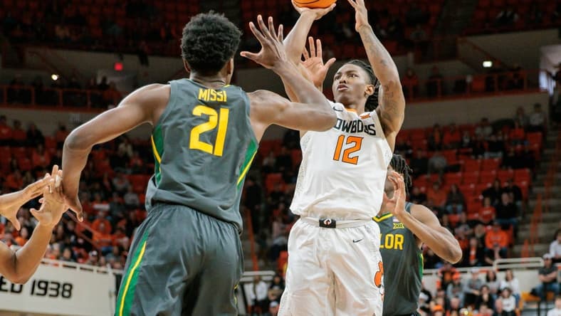 Jan 6, 2024; Stillwater, Oklahoma, USA; Oklahoma State Cowboys guard Javon Small (12) puts up a shot over Baylor Bears center Yves Missi (21) during the first half at Gallagher-Iba Arena. Mandatory Credit: William Purnell-USA TODAY Sports