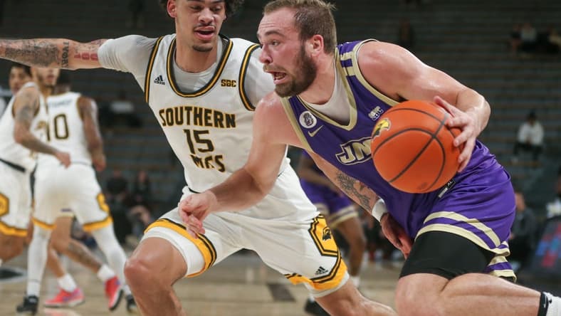 Jan 6, 2024; Hattiesburg, Mississippi, USA; James Madison Dukes guard Noah Freidel (1) drives on Southern Miss Golden Eagles guard Donovan Ivory (15) during the first half at Reed Green Coliseum. Mandatory Credit: Chuck Cook-USA TODAY Sports