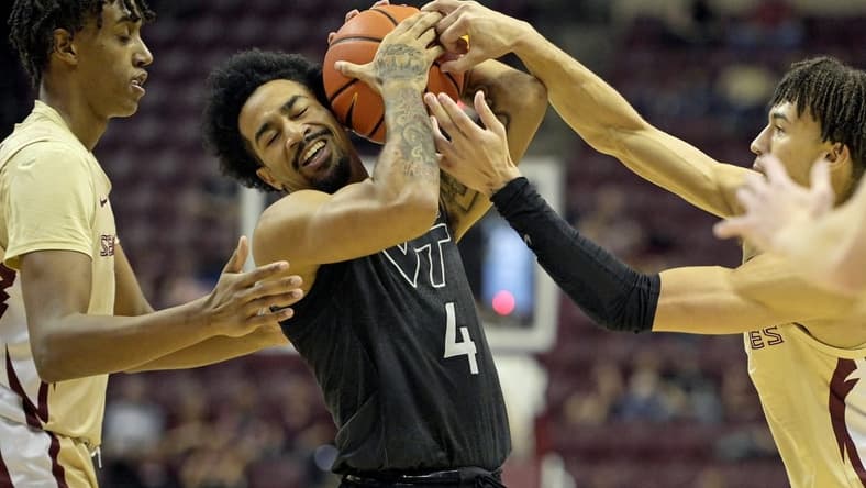 Jan 6, 2024; Tallahassee, Florida, USA; Virginia Tech Hokies forward Mekhi Long (4) wrestles a ball away from Florida State Seminoles guard Jalen Warley (1) during the game at Donald L. Tucker Center. Mandatory Credit: Melina Myers-USA TODAY Sports
