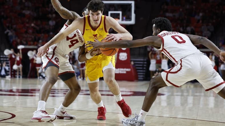 Jan 6, 2024; Norman, Oklahoma, USA; Iowa State Cyclones forward Milan Momcilovic (22) drives between Oklahoma Sooners forward Jalon Moore (14) and guard Le'Tre Darthard (0) during the first half at Lloyd Noble Center. Mandatory Credit: Alonzo Adams-USA TODAY Sports