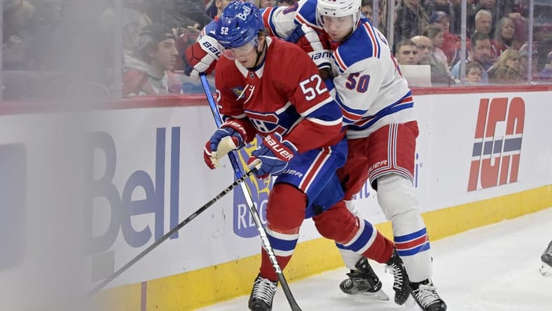 Jan 6, 2024; Montreal, Quebec, CAN; Montreal Canadiens defenseman Justin Barron (52) plays the puck and New York Rangers forward Will Cuylle (50) forechecks during the first period at the Bell Centre. Mandatory Credit: Eric Bolte-USA TODAY Sports