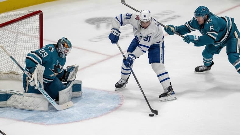 Jan 6, 2024; San Jose, California, USA; Toronto Maple Leafs center John Tavares (91) passes the puck to Toronto Maple Leafs right wing William Nylander (not pictured) in front of San Jose Sharks goaltender Mackenzie Blackwood (29) during the third period at SAP Center at San Jose. Mandatory Credit: Neville E. Guard-USA TODAY Sports