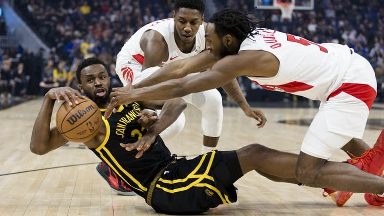 Jan 7, 2024; San Francisco, California, USA; Golden State Warriors forward Andrew Wiggins (22) and Toronto Raptors guard Immanuel Quickley (5) and forward RJ Barrett (9) battle for possession during the first half at Chase Center. Mandatory Credit: John Hefti-USA TODAY Sports