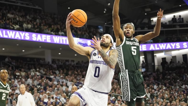 Jan 7, 2024; Evanston, Illinois, USA; Michigan State Spartans guard Tre Holloman (5) defends Northwestern Wildcats guard Boo Buie (0) during the second half at Welsh-Ryan Arena. Mandatory Credit: David Banks-USA TODAY Sports