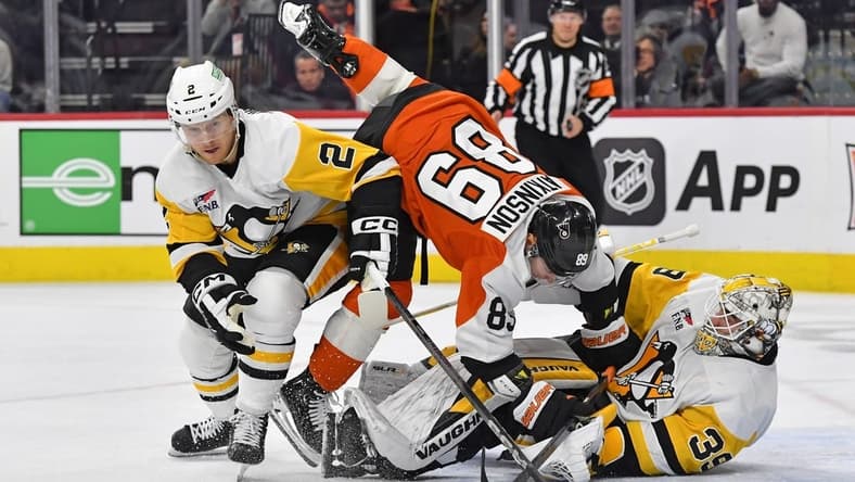 Jan 8, 2024; Philadelphia, Pennsylvania, USA; Pittsburgh Penguins defenseman Chad Ruhwedel (2) reaches for the puck as Philadelphia Flyers right wing Cam Atkinson (89) runs into goaltender Tristan Jarry (35) during the first period at Wells Fargo Center. Mandatory Credit: Eric Hartline-USA TODAY Sports