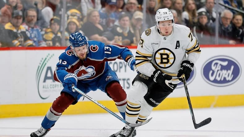 Jan 8, 2024; Denver, Colorado, USA; Boston Bruins defenseman Charlie McAvoy (73) controls the puck ahead of Colorado Avalanche right wing Valeri Nichushkin (13) in the third period at Ball Arena. Mandatory Credit: Isaiah J. Downing-USA TODAY Sports