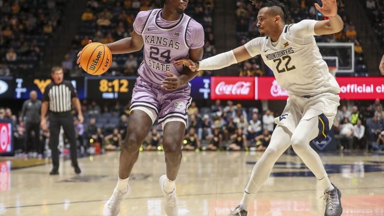Jan 9, 2024; Morgantown, West Virginia, USA; Kansas State Wildcats forward Arthur Kaluma (24) dribbles against West Virginia Mountaineers forward Josiah Harris (22) during the first half at WVU Coliseum. Mandatory Credit: Ben Queen-USA TODAY Sports