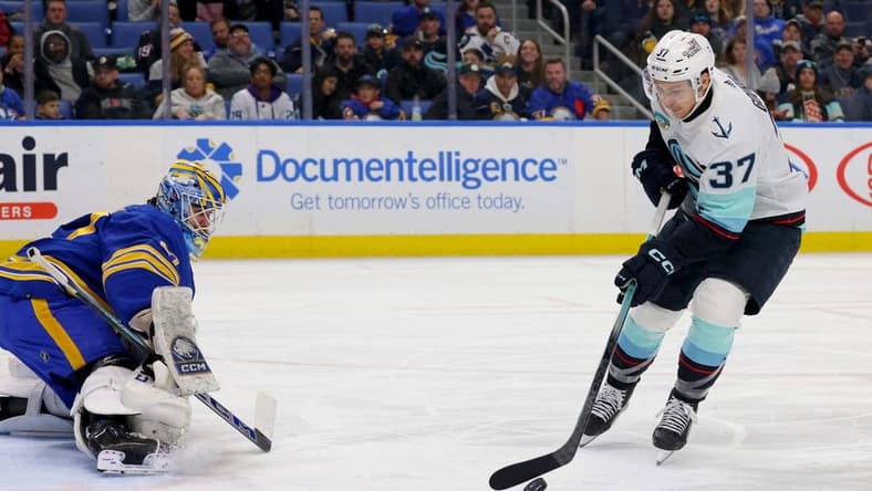 Jan 9, 2024; Buffalo, New York, USA; Seattle Kraken center Yanni Gourde (37) looks to take a shot on Buffalo Sabres goaltender Devon Levi (27) during the third period at KeyBank Center. Mandatory Credit: Timothy T. Ludwig-USA TODAY Sports