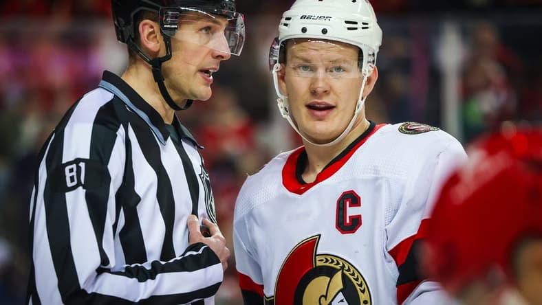 Jan 9, 2024; Calgary, Alberta, CAN; Ottawa Senators left wing Brady Tkachuk (7) and linesman Ryan Daisy (81) exchange words during the second period against the Calgary Flames at Scotiabank Saddledome. Mandatory Credit: Sergei Belski-USA TODAY Sports