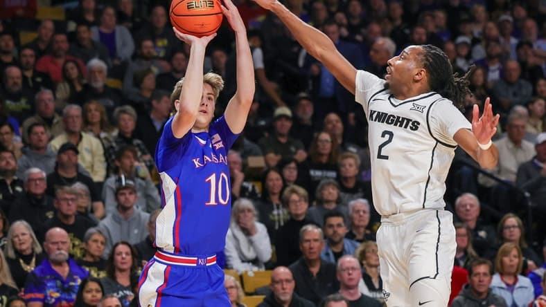 Jan 10, 2024; Orlando, Florida, USA; Kansas Jayhawks guard Johnny Furphy (10) shoots a three point basket against UCF Knights guard Shemarri Allen (2) during the first period against the UCF Knights at Addition Financial Arena. Mandatory Credit: Mike Watters-USA TODAY Sports