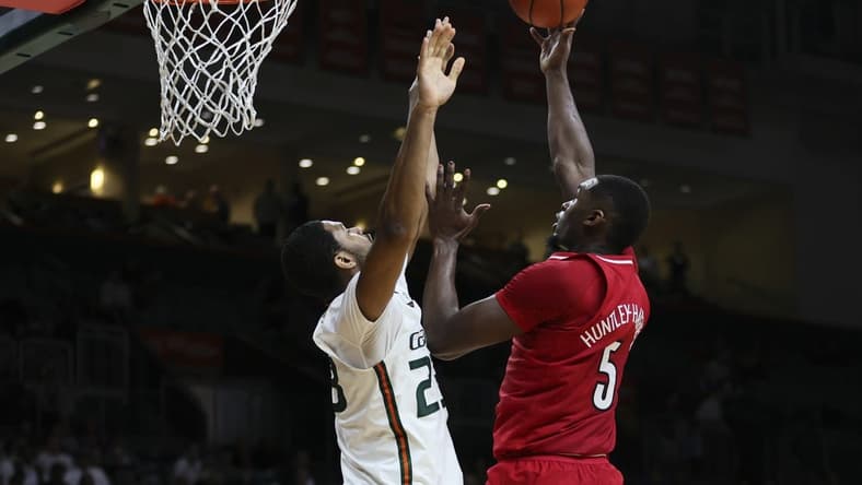 Jan 10, 2024; Coral Gables, Florida, USA; Louisville Cardinals forward Brandon Huntley-Hatfield (5) shoots the basketball over Miami Hurricanes forward AJ Casey (23) during the first half at Watsco Center. Mandatory Credit: Sam Navarro-USA TODAY Sports