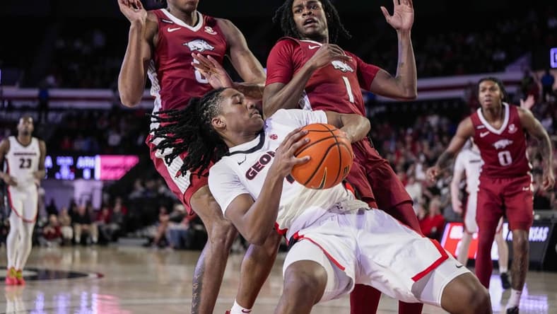 Jan 10, 2024; Athens, Georgia, USA; Georgia Bulldogs guard Silas Demary Jr. (4) controls the ball against Arkansas Razorbacks forward Chandler Lawson (8) and guard Keyon Menifield Jr. (1) during the first half at Stegeman Coliseum. Mandatory Credit: Dale Zanine-USA TODAY Sports