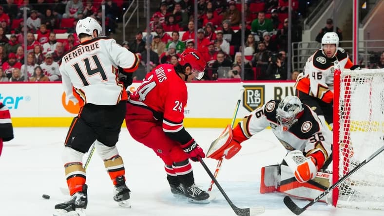 Jan 11, 2024; Raleigh, North Carolina, USA; Anaheim Ducks goaltender John Gibson (36) makes a save on Carolina Hurricanes center Seth Jarvis (24) shot during the first period at PNC Arena. Mandatory Credit: James Guillory-USA TODAY Sports