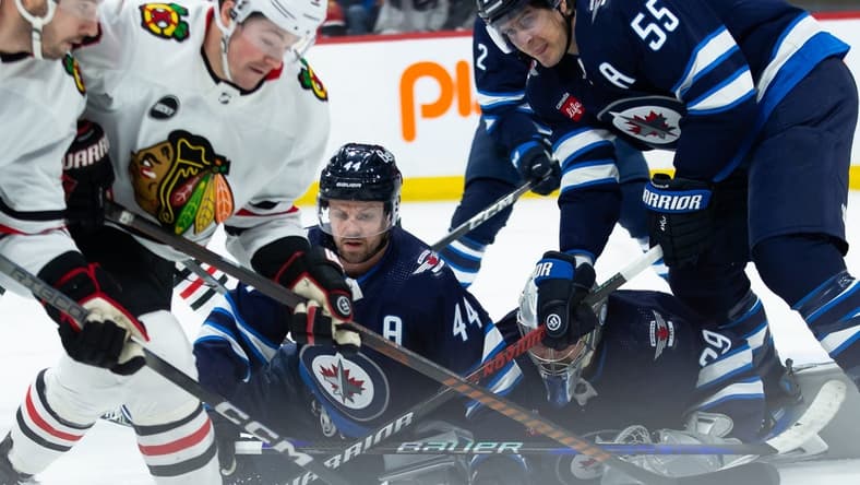 Jan 11, 2024; Winnipeg, Manitoba, CAN; Chicago Blackhawks forward Ryan Donato (8), Winnipeg Jets defenseman Josh Morrissey (44) and Winnipeg Jets forward Mark Scheifele (55) looks for the puck in front of Winnipeg Jets goalie Connor Hellebuyck (37) during the first period at Canada Life Centre. Mandatory Credit: Terrence Lee-USA TODAY Sports