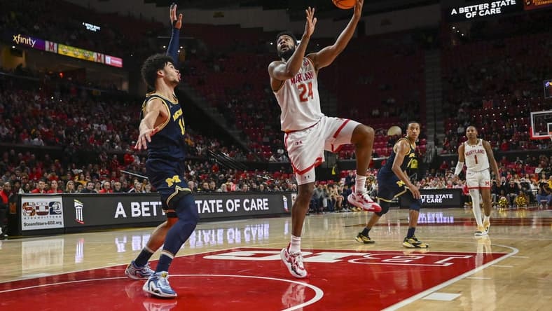 Jan 11, 2024; College Park, Maryland, USA;  Maryland Terrapins forward Donta Scott (24) shoots a sky hook over Michigan Wolverines forward Olivier Nkamhoua (13) during the second half at Xfinity Center. Mandatory Credit: Tommy Gilligan-USA TODAY Sports