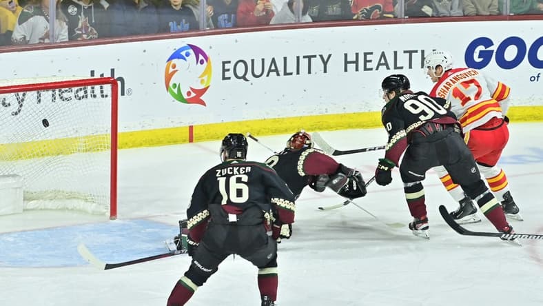 Jan 11, 2024; Tempe, Arizona, USA; Calgary Flames center Yegor Sharangovich (17) scores a short handed goal on Arizona Coyotes goaltender Karel Vejmelka (70) as left wing Jason Zucker (16) and defenseman J.J. Moser (90) defend in the first period at Mullett Arena. Mandatory Credit: Matt Kartozian-USA TODAY Sports