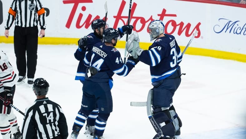 Jan 11, 2024; Winnipeg, Manitoba, CAN; Winnipeg Jets goalie Laurent Boissoit (39) is congratulated by his team mates on his win against the Chicago Blackhawks at the end of the third period at Canada Life Centre. Mandatory Credit: Terrence Lee-USA TODAY Sports