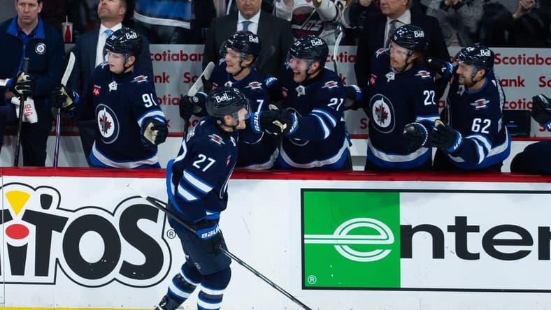 Jan 11, 2024; Winnipeg, Manitoba, CAN; Winnipeg Jets forward Nikolaj Ehlers (27) is congratulated by his team mates on his goal against Chicago Blackhawks goalie Petr Mrazek (34) during the third period at Canada Life Centre. Mandatory Credit: Terrence Lee-USA TODAY Sports