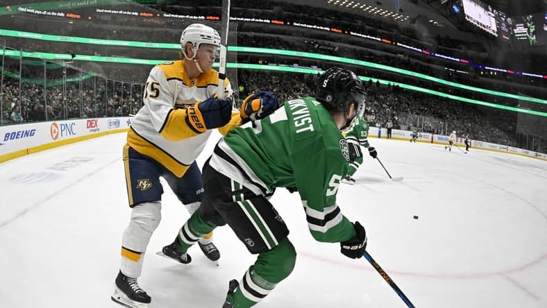 Jan 12, 2024; Dallas, Texas, USA; Nashville Predators center Juuso Parssinen (75) checks Dallas Stars defenseman Nils Lundkvist (5) during the first period at the American Airlines Center. Mandatory Credit: Jerome Miron-USA TODAY Sports