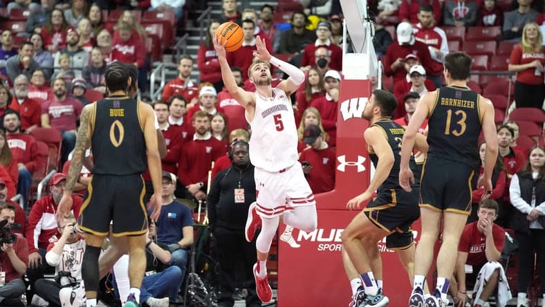 Jan 13, 2024; Madison, Wisconsin, USA; Wisconsin Badgers forward Tyler Wahl (5) scores against Northwestern Wildcats forward Blake Preston (32) during the first half at the Kohl Center. Mandatory Credit: Kayla Wolf-USA TODAY Sports