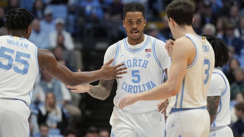Jan 13, 2024; Chapel Hill, North Carolina, USA; North Carolina Tar Heels forward Armando Bacot (5) reacts with forward Harrison Ingram (55) and guard Cormac Ryan (3) in the first half at Dean E. Smith Center. Mandatory Credit: Bob Donnan-USA TODAY Sports