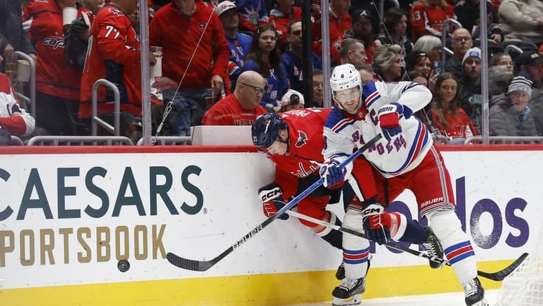 Jan 13, 2024; Washington, District of Columbia, USA; Washington Capitals center Aliaksei Protas (21) and New York Rangers defenseman Jacob Trouba (8) battle for the puck in the first period at Capital One Arena. Mandatory Credit: Geoff Burke-USA TODAY Sports