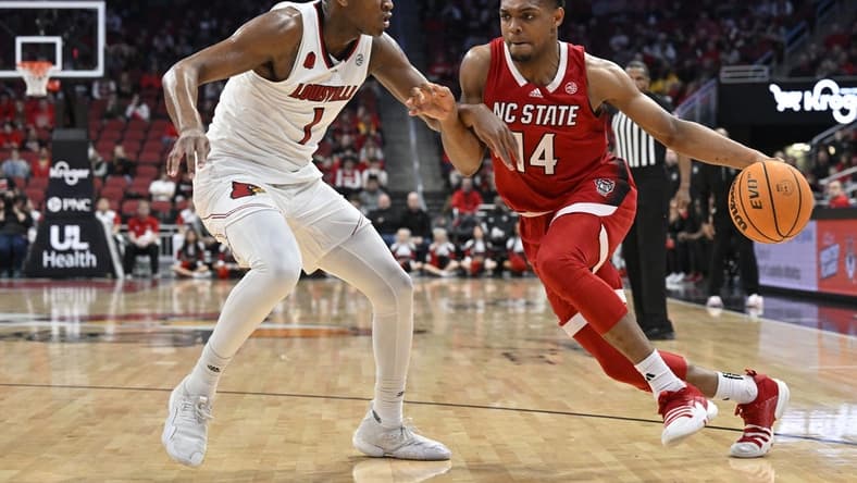 Jan 13, 2024; Louisville, Kentucky, USA;  North Carolina State Wolfpack guard Casey Morsell (14) dribbles the ball against Louisville Cardinals guard Curtis Williams (1) during the first half at KFC Yum! Center.  Mandatory Credit: Jamie Rhodes-USA TODAY Sports