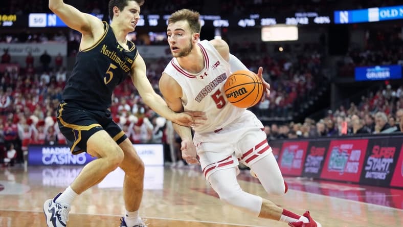 Jan 13, 2024; Madison, Wisconsin, USA; Wisconsin Badgers forward Tyler Wahl (5) dribbles the ball against Northwestern Wildcats guard Ryan Langborg (5) during the second half at the Kohl Center. Mandatory Credit: Kayla Wolf-USA TODAY Sports