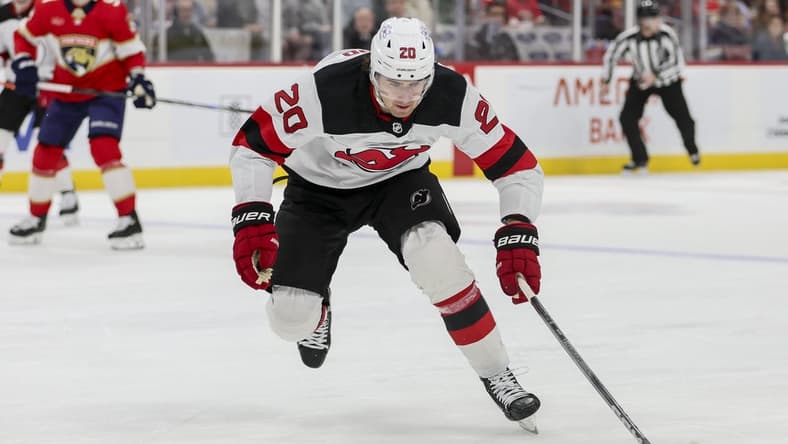 Jan 13, 2024; Sunrise, Florida, USA; New Jersey Devils center Michael McLeod (20) moves the puck against the Florida Panthers during the first period at Amerant Bank Arena. Mandatory Credit: Sam Navarro-USA TODAY Sports