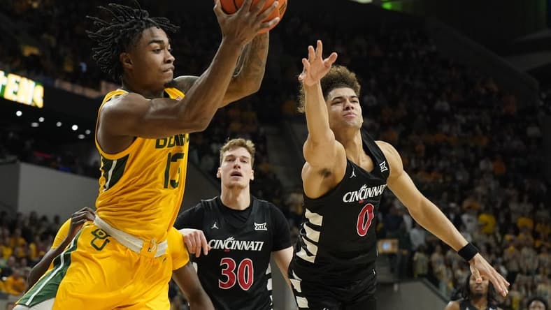 Jan 13, 2024; Waco, Texas, USA; Baylor Bears guard Langston Love (13) grabs the rebound in front of Cincinnati Bearcats guard Dan Skillings Jr. (0) during the first half at Paul and Alejandra Foster Pavilion. Mandatory Credit: Raymond Carlin III-USA TODAY Sports