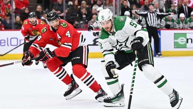 Jan 13, 2024; Chicago, Illinois, USA; Dallas Stars forward Tyler Seguin (91) controls the puck while being defended by Chicago Blackhawks defenseman Seth Jones (4) in the second period at United Center. Mandatory Credit: Jamie Sabau-USA TODAY Sports