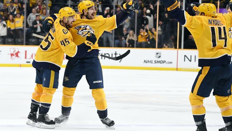 Jan 13, 2024; Nashville, Tennessee, USA; Nashville Predators defenseman Alexandre Carrier (45) and left wing Filip Forsberg (9) celebrate after the game-winning goal during the third period against the New York Islanders at Bridgestone Arena. Mandatory Credit: Christopher Hanewinckel-USA TODAY Sports