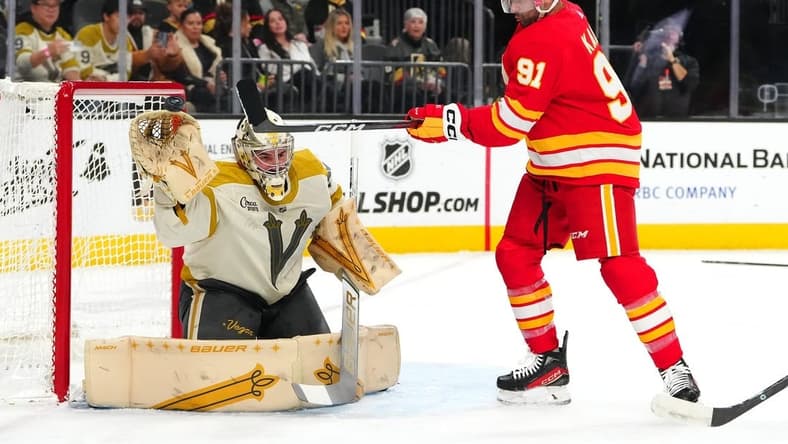 Jan 13, 2024; Las Vegas, Nevada, USA; Calgary Flames center Nazem Kadri (91) attempts to deflect a shot towards Vegas Golden Knights goaltender Logan Thompson (36) during the first period at T-Mobile Arena. Mandatory Credit: Stephen R. Sylvanie-USA TODAY Sports