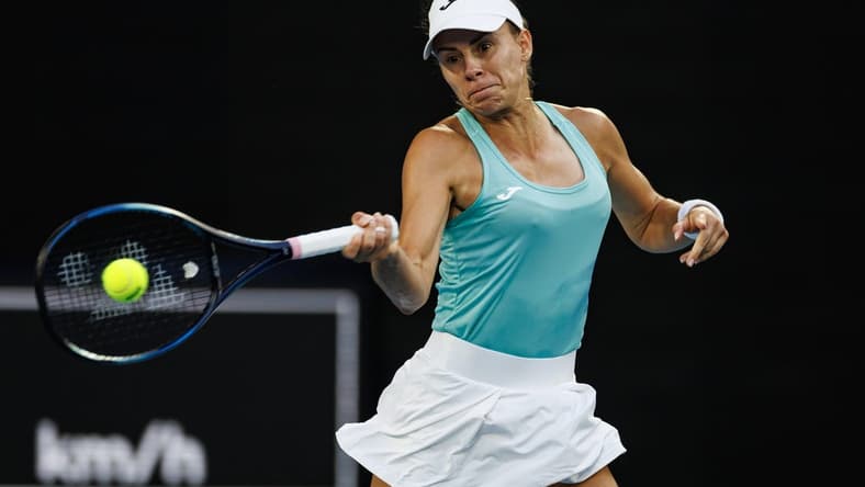 Jan 14, 2024; Melbourne, Victoria, Australia; Magda Linette of Poland hits a shot against Caroline Wozniacki of Denmark in the first round of the women s singles.Mandatory Credit: Mike Frey-USA TODAY Sports