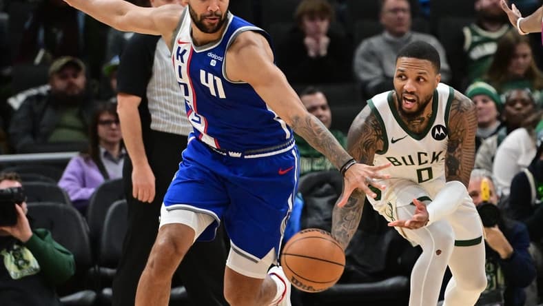 Jan 14, 2024; Milwaukee, Wisconsin, USA; Milwaukee Bucks guard Damian Lillard (0) passes the ball away from Sacramento Kings forward Trey Lyles (41) in overtime at Fiserv Forum. Mandatory Credit: Benny Sieu-USA TODAY Sports