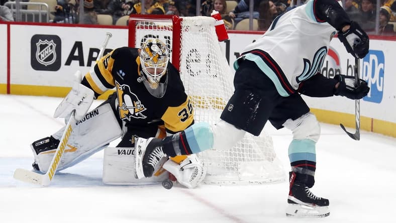 Jan 15, 2024; Pittsburgh, Pennsylvania, USA; Pittsburgh Penguins goaltender Tristan Jarry (35) makes a save against Seattle Kraken Jaden Schwartz (right) during the second period at PPG Paints Arena. Mandatory Credit: Charles LeClaire-USA TODAY Sports