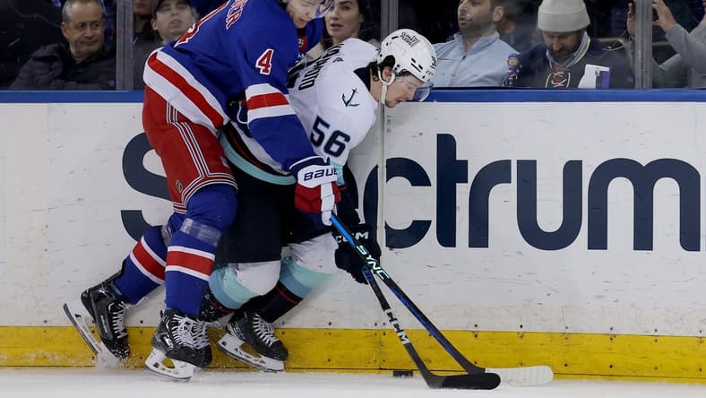 Jan 16, 2024; New York, New York, USA; New York Rangers defenseman Braden Schneider (4) fights for the puck against Seattle Kraken right wing Kailer Yamamoto (56) during the second period at Madison Square Garden. Mandatory Credit: Brad Penner-USA TODAY Sports
