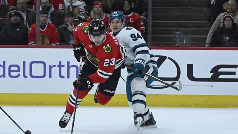 Jan 16, 2024; Chicago, Illinois, USA; Chicago Blackhawks center Philipp Kurashev (23) gets tripped by San Jose Sharks left wing Alexander Barabanov (94) during the first period at United Center. Mandatory Credit: Matt Marton-USA TODAY Sports