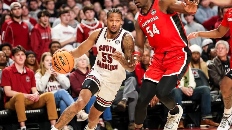 Jan 16, 2024; Columbia, South Carolina, USA; South Carolina Gamecocks guard Ta'Lon Cooper (55) drives around Georgia Bulldogs center Russel Tchewa (54) in the first half at Colonial Life Arena. Mandatory Credit: Jeff Blake-USA TODAY Sports