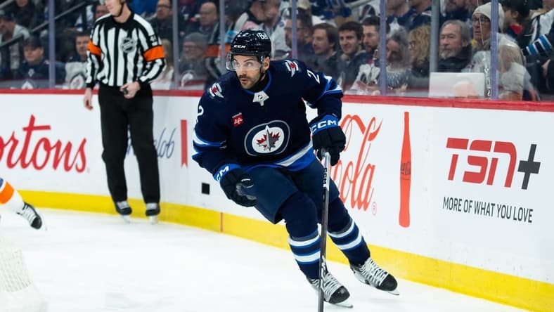 Jan 16, 2024; Winnipeg, Manitoba, CAN; Winnipeg Jets defenseman Dylan DeMelo (2) looks to make a pass against the New York Islanders during the first period at Canada Life Centre. Mandatory Credit: Terrence Lee-USA TODAY Sports