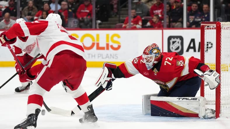 Jan 17, 2024; Sunrise, Florida, USA; Florida Panthers goaltender Sergei Bobrovsky (72) knocks the puck away from Detroit Red Wings left wing J.T. Compher (37) during the first period at Amerant Bank Arena. Mandatory Credit: Jasen Vinlove-USA TODAY Sports
