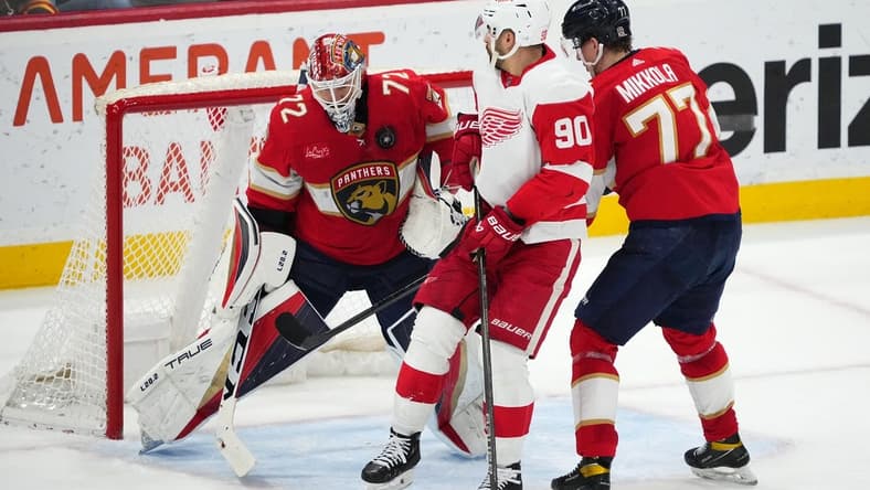 Jan 17, 2024; Sunrise, Florida, USA; Florida Panthers goaltender Sergei Bobrovsky (72) makes a save behind defenseman Niko Mikkola (77) and Detroit Red Wings center Joe Veleno (90) during the second period at Amerant Bank Arena. Mandatory Credit: Jasen Vinlove-USA TODAY Sports