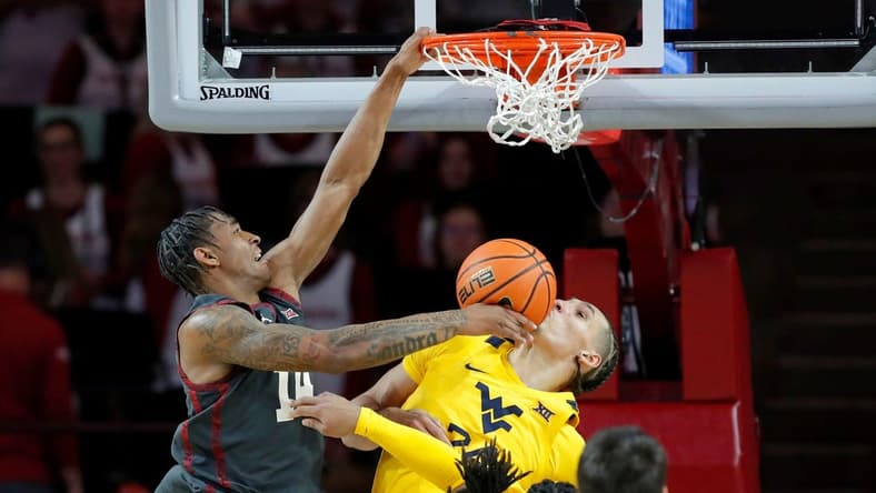 Oklahoma Sooners forward Jalon Moore (14) dunks the ball on West Virginia Mountaineers forward Patrick Suemnick (24) during a college basketball game between the University of Oklahoma Sooners (OU) and the West Virginia Mountaineers at Lloyd Noble Center in Norman, Okla., Okla., Wednesday, Jan. 17, 2024.