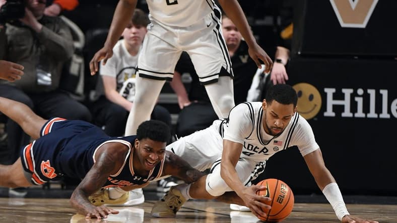Jan 17, 2024; Nashville, Tennessee, USA; Auburn Tigers guard K.D. Johnson (0) and Vanderbilt Commodores guard Isaiah West (4) dive for a loose ball during the first half at Memorial Gymnasium. Mandatory Credit: Christopher Hanewinckel-USA TODAY Sports