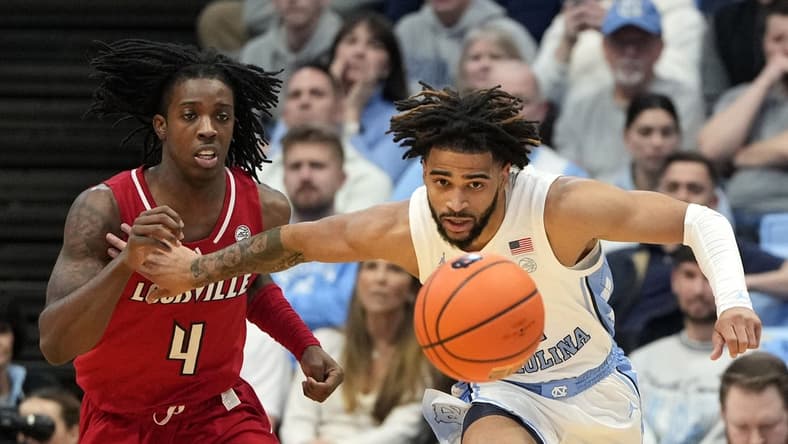 Jan 17, 2024; Chapel Hill, North Carolina, USA; Louisville Cardinals guard Ty-Laur Johnson (4) and North Carolina Tar Heels guard RJ Davis (4) fight for the ball in the first half at Dean E. Smith Center. Mandatory Credit: Bob Donnan-USA TODAY Sports