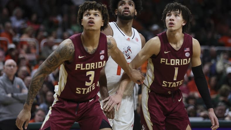 Jan 17, 2024; Coral Gables, Florida, USA; Miami Hurricanes forward Norchad Omier (15) looks on as Florida State Seminoles forward Cam Corhen (3) and guard Jalen Warley (1) defend during the second half at Watsco Center. Mandatory Credit: Sam Navarro-USA TODAY Sports