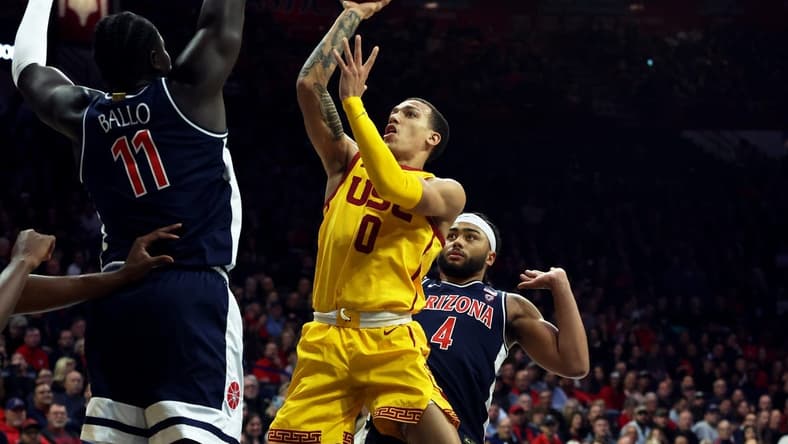 Jan 17, 2024; Tucson, Arizona, USA; USC Trojans guard Kobe Johnson (0) drives to the net against Arizona Wildcats center Oumar Ballo (11) during the first half at McKale Center. Mandatory Credit: Zachary BonDurant-USA TODAY Sports
