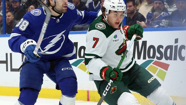 Jan 18, 2024; Tampa, Florida, USA; Tampa Bay Lightning left wing Brandon Hagel (38) ands Minnesota Wild defenseman Brock Faber (7) skate after the puck during the first period at Amalie Arena. Mandatory Credit: Kim Klement Neitzel-USA TODAY Sports