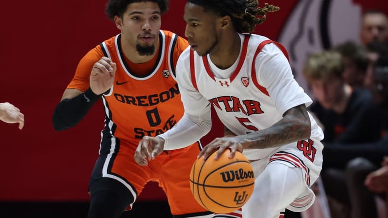 Jan 18, 2024; Salt Lake City, Utah, USA; Utah Utes guard Deivon Smith (5) drives against Oregon State Beavers guard Jordan Pope (0) during the first half at Jon M. Huntsman Center. Mandatory Credit: Rob Gray-USA TODAY Sports